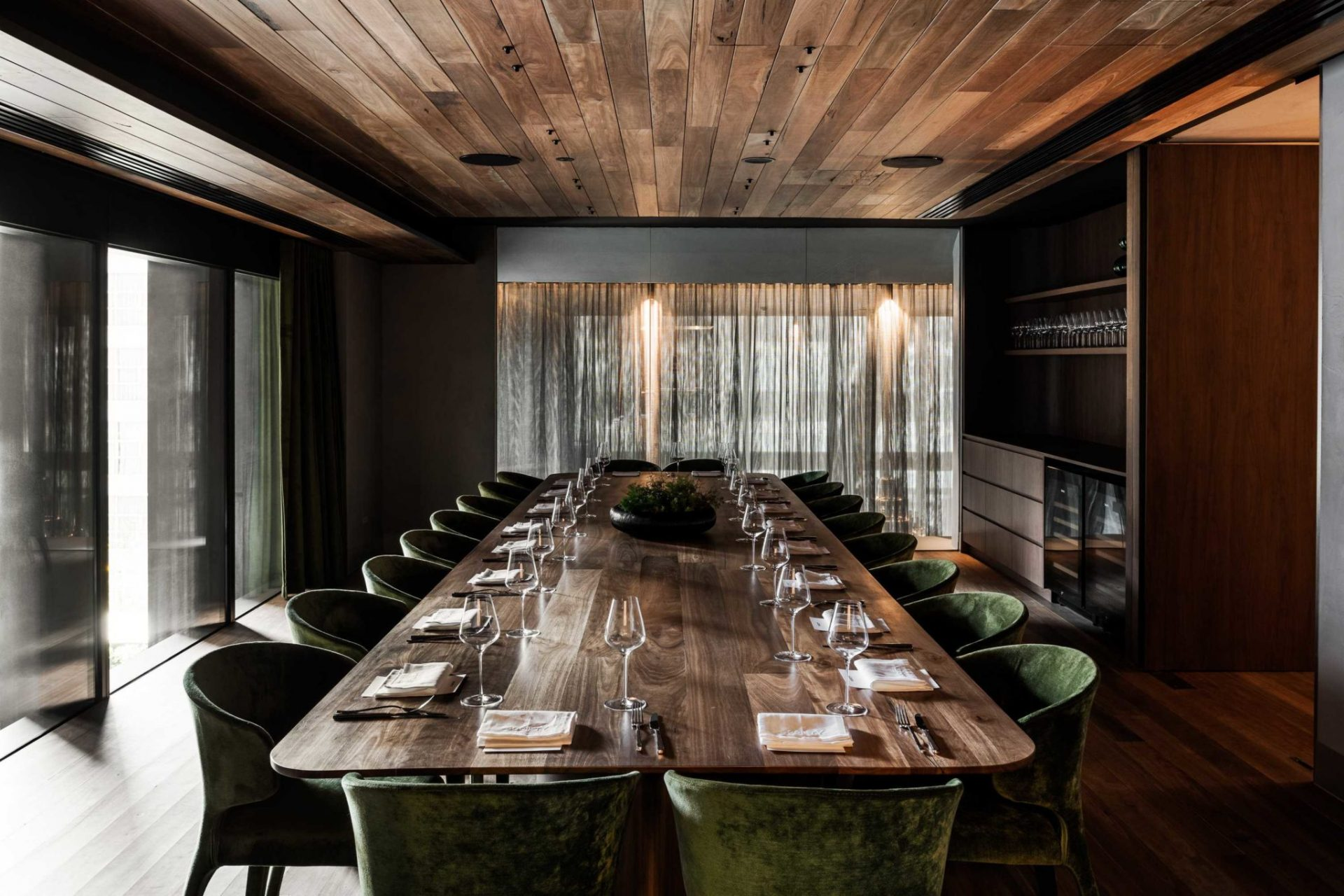A private dining room with a long wooden table set for a small group lunch.