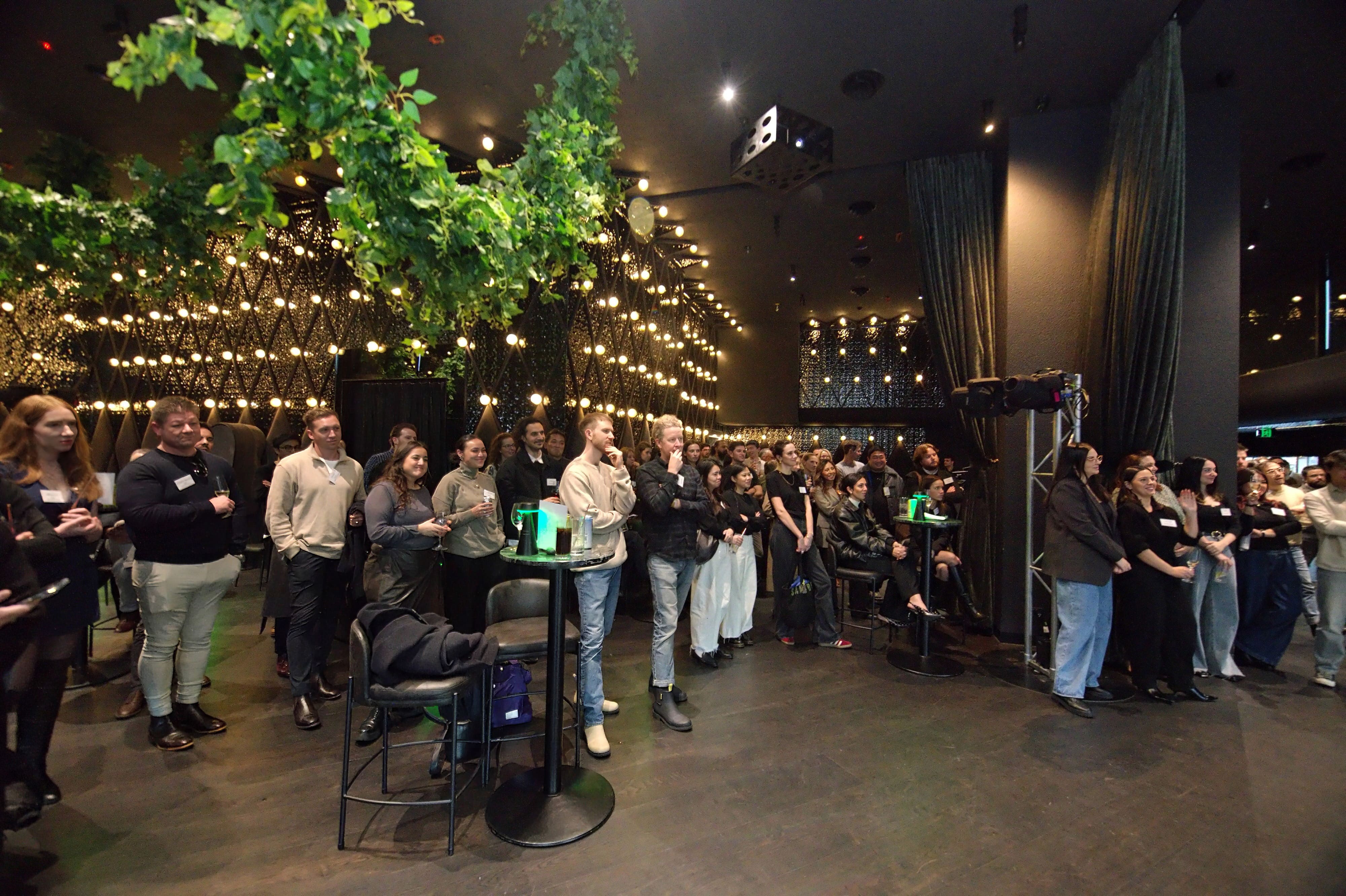 Guests gathered at an Overdose & Chill event in a venue with hanging greenery and warm lights.